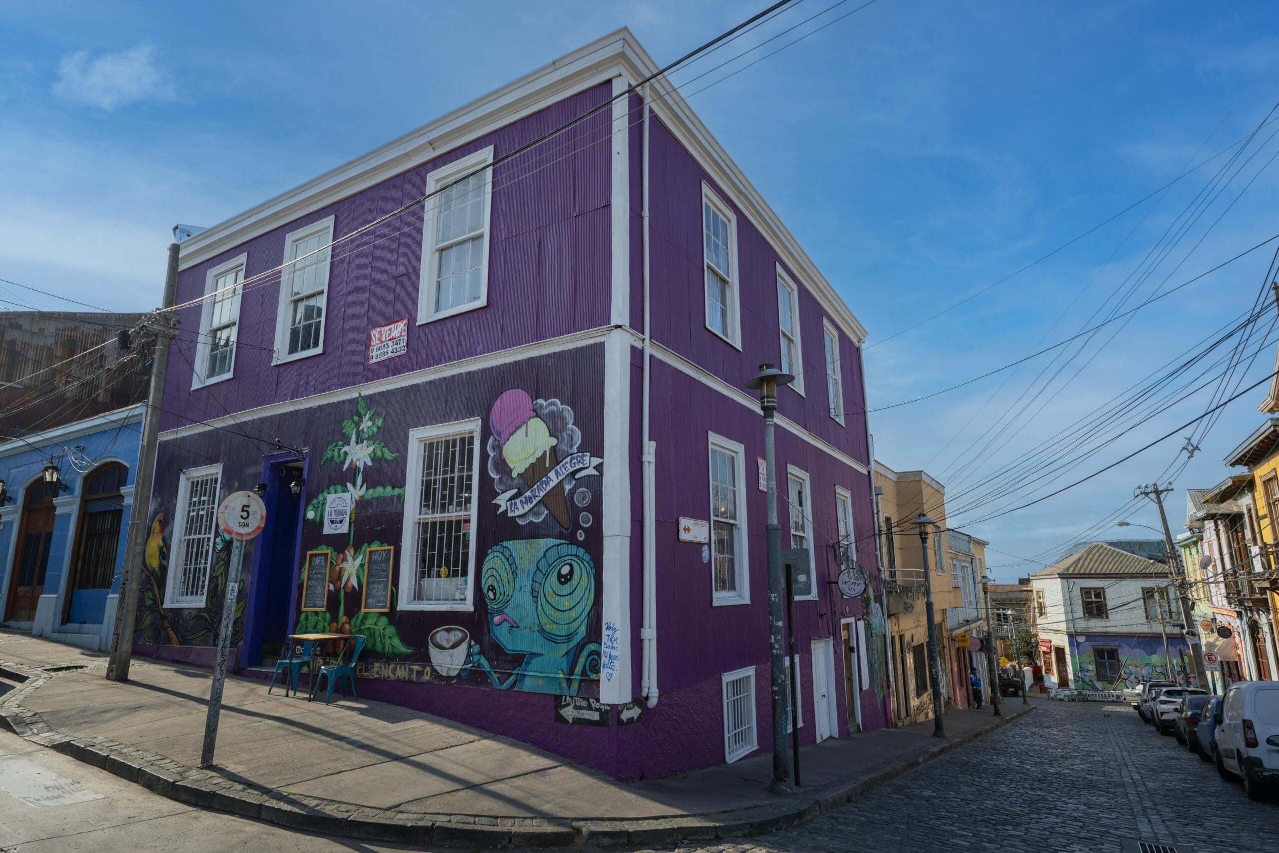Colorful mural-painted building on a lively street in Valparaíso, Chile.